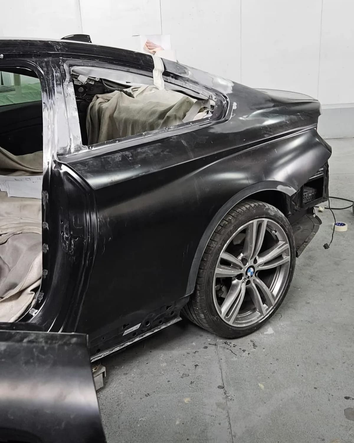 Aile arrière de BMW masticée et poncée, custode déposée, prête à recevoir l'apprêt